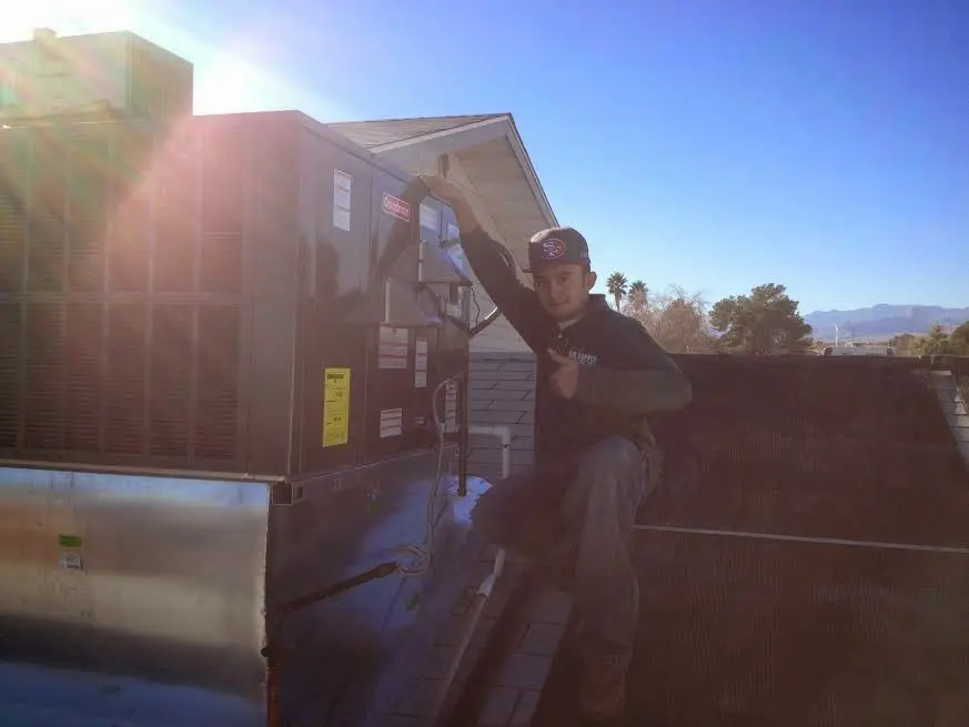 HVAC technician performing AC Tune-Up on a rooftop unit in Kennedy
